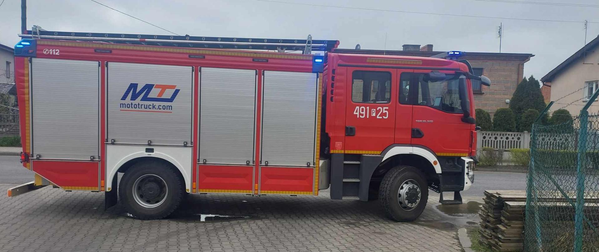 Zdjęcie ukazuje auto pożarnicze na światłach błyskowych