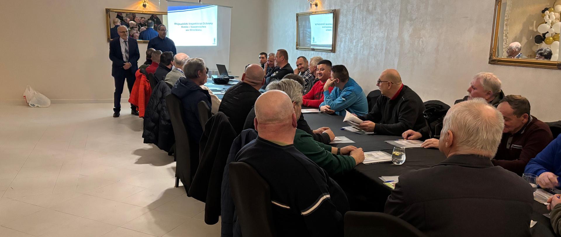 Rolnicy słuchający prezentacji przedstawiciela inspekcji