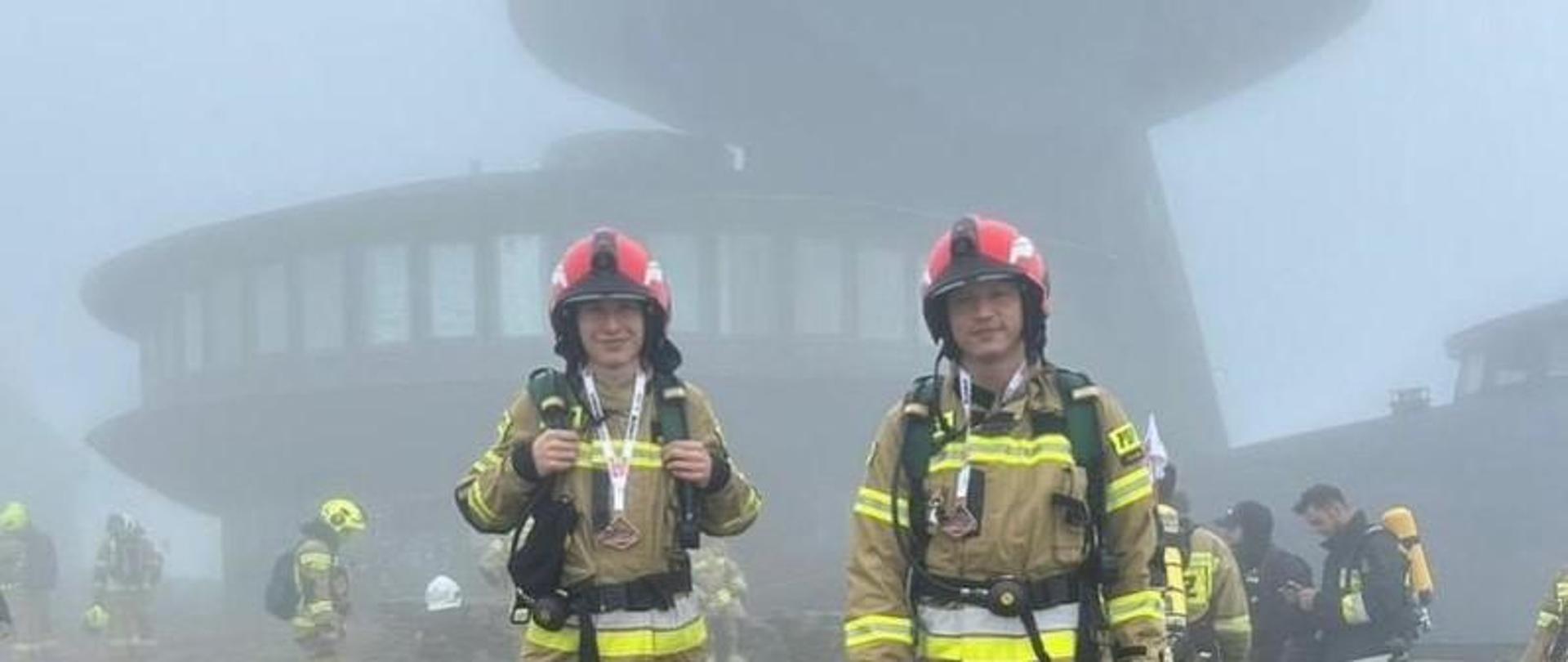 Strażacy w umundurowaniu bojowym stojący na górze Śnieżka