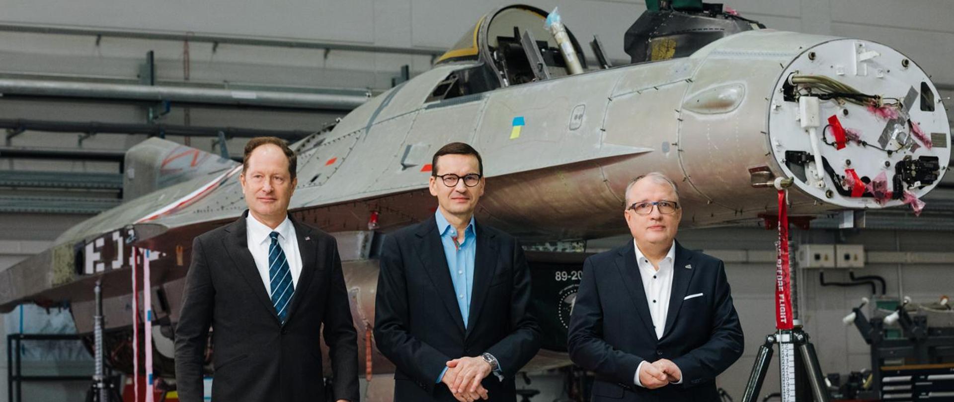 3 osoby na tle samolotu