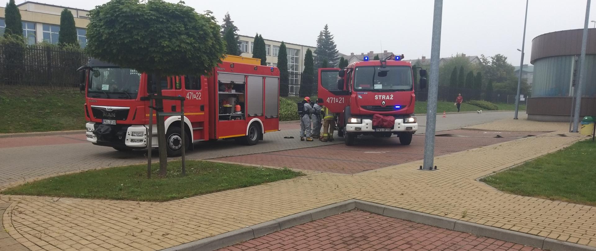 Zdjęcie przedstawia pojazdy gaśnicze oraz strażaków