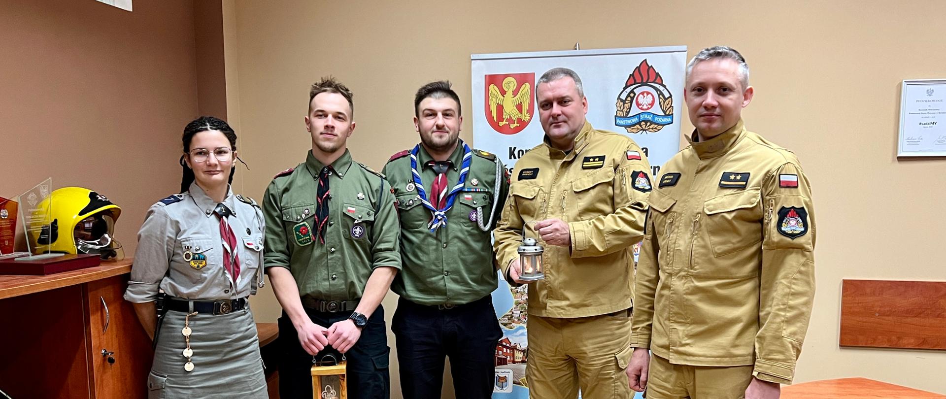 Kadra Komendy Powiatowej PSP w Kwidzynie wraz z harcerzami pozują do zdjęcia.
