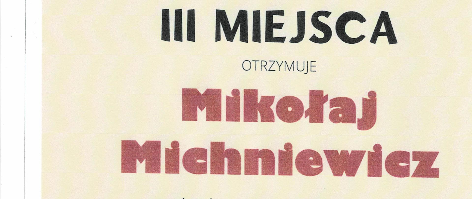 Na jasnym tle dyplomu, pośrodku na górze widnieje napis „Państwowa szkoła Muzyczna I st. Nr 3 im. H. Wieniawskiego w Warszawie”, poniżej czerwonymi literami „MISTRZ KLAWIATURY” XIV Ogólnopolski konkurs Pianistyczny dla uczniów szkół muzycznych I i II stopnia,, niżej „DYPLOM LAUREATA III MIEJSCA otrzymuje Mikołaj Michniewicz uczeń Państwowej szkoły Muzycznej I st. om. E. Młynarskiego w Augustowie klasy fortepianu p. Anetty Pękali”, niżej podpisy trzech jurorów: prof. dr hab. Alicja Kledzik, prof. dr. hab. Joanna Ławrynowicz-Just, prof. dr hab. Paweł Zawadzki. Na dole dyplomu fragment klawiatury , na której napis: Warszawa 20-21 kwietnia 2023 r.