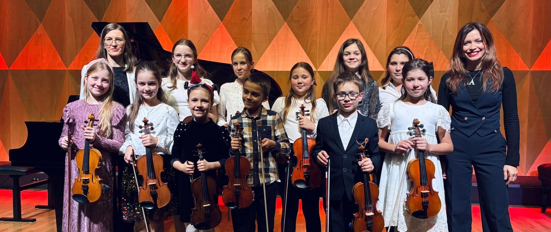 Grupa uczniów na scenie sali koncertowej