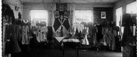 Stare zdjęcie przedstawiające ekspozycję sukienek w pomieszczeniu szkolnym
