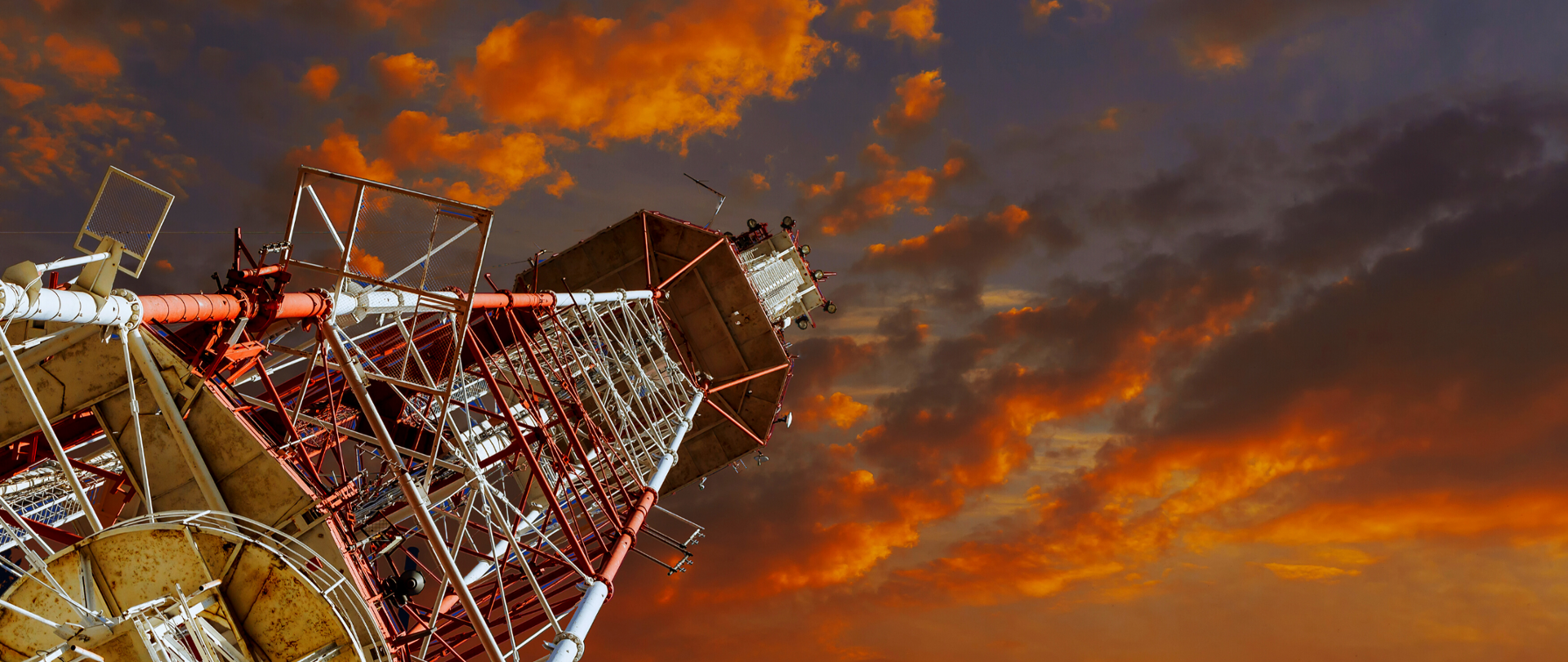 Maszt telekomunikacyjny widziany od dołu. W tle niebo.