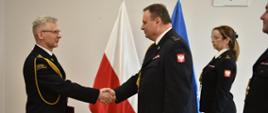 Sala w komendzie wojewódzkiej komendant wojewódzki st. bryg. Piotr Rudecki gratuluje podaniem ręki właśnie powołanemu komendantowi powiatowemu PSP w Brzezinach starszemu brygadierowi Mariuszowi Kaczmarskiemu na zdjęciu obeni również st. bryg. Sebastian Kościsty zastępca łódzkiego komendanta wojewódzkiego PSP w Łodzi oraz bryg. Agnieszka Wasylik zastępca naczelnika Wydziału Kadr Komendy Wojewódzkiej PSP w Łodzi.