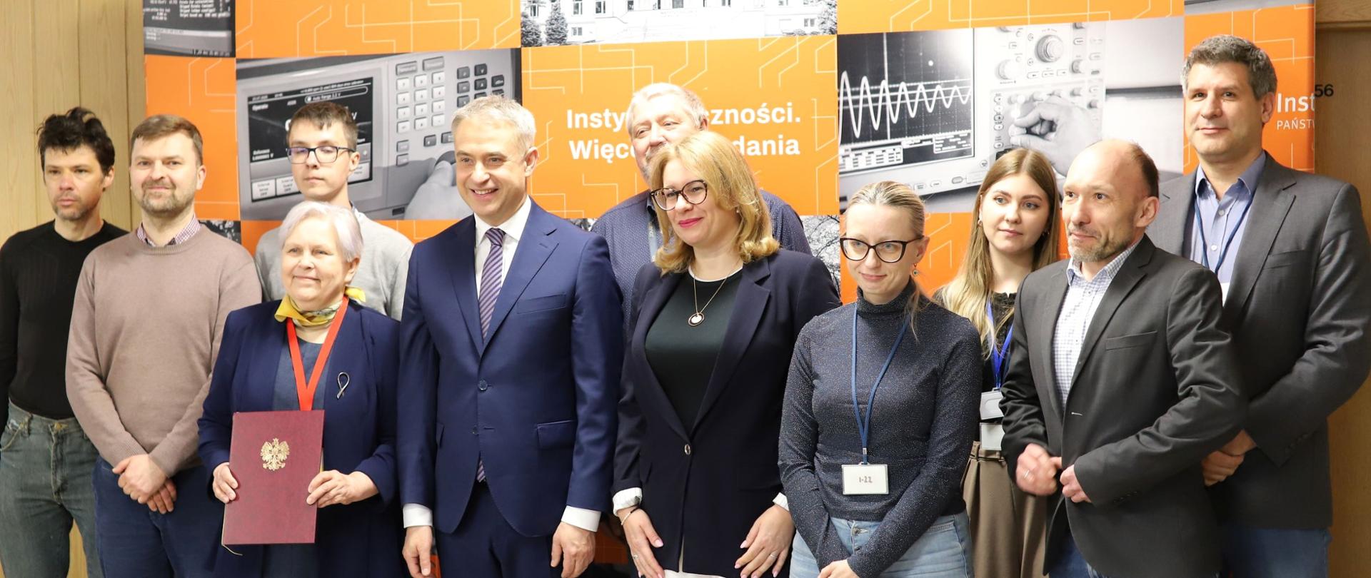 Wicepremier, Minister Cyfryzacji Krzysztof Gawkowski z dr inż. Elżbietą Andrukiewicz i zespołem Laboratorium Oceny Bezpieczeństwa Zakładu Cyberbezpieczeństwa oraz Technologii i Zastosowania Internetu w Instytucie Łączności.