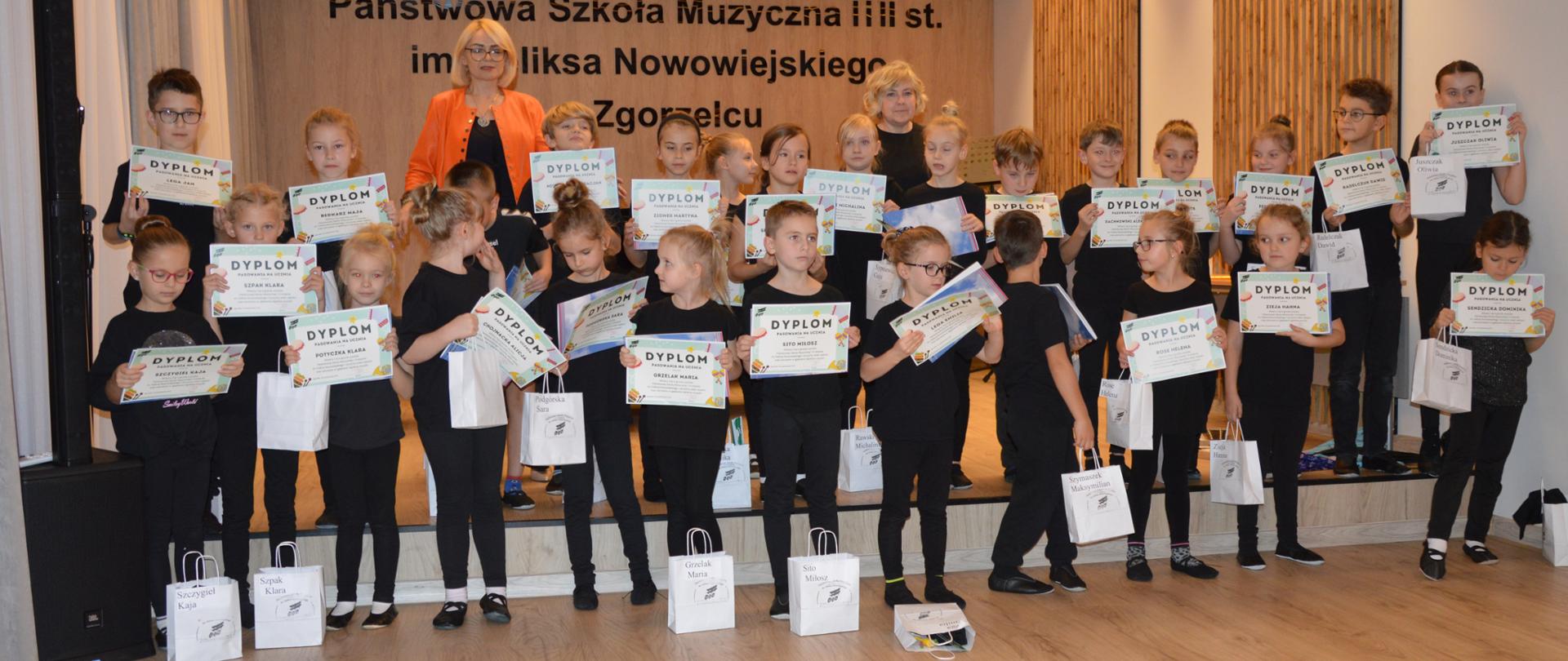 Zdjęcie grupowe uczniów klasy pierwszej po pasowaniu. 