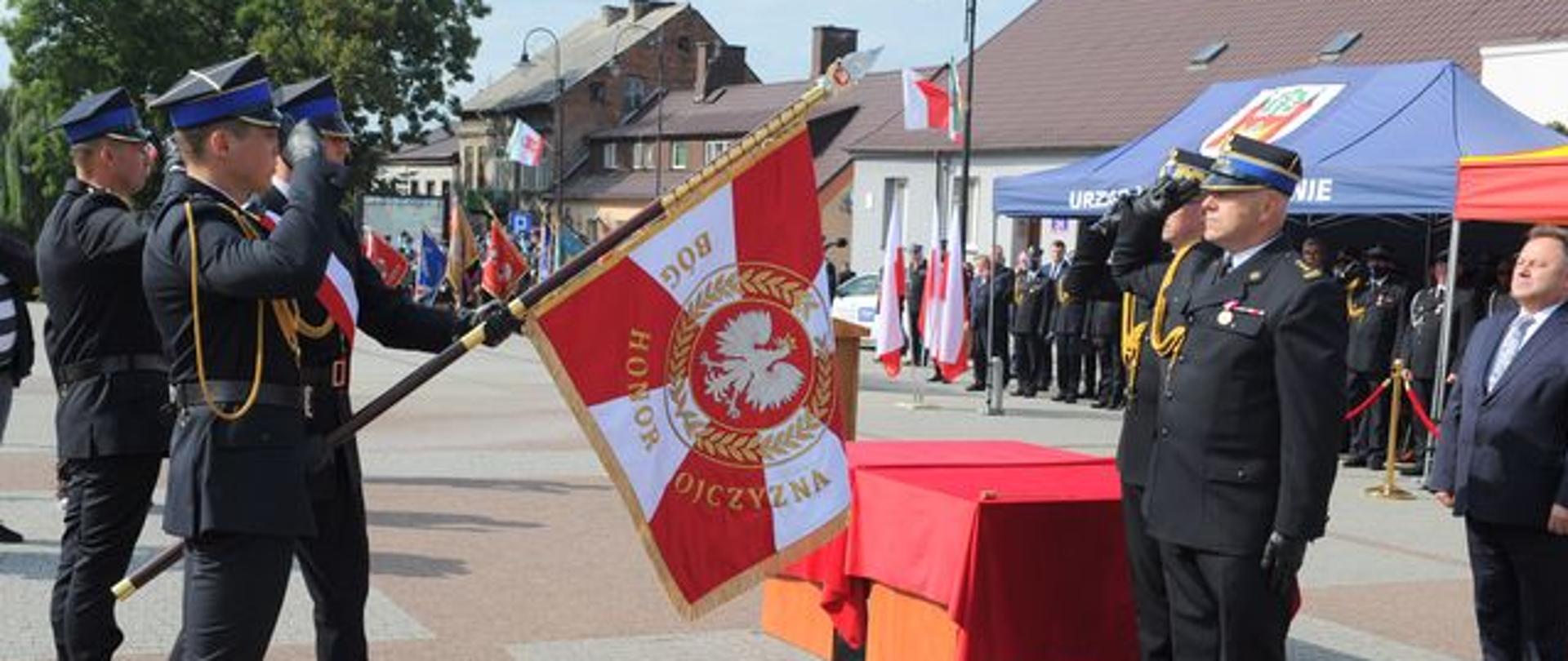 Nadanie sztandaru Komendzie Powiatowej PSP w Lipnie – na zdjęciu strażacy oddają honor sztandarowi– w tle zaproszeni goście