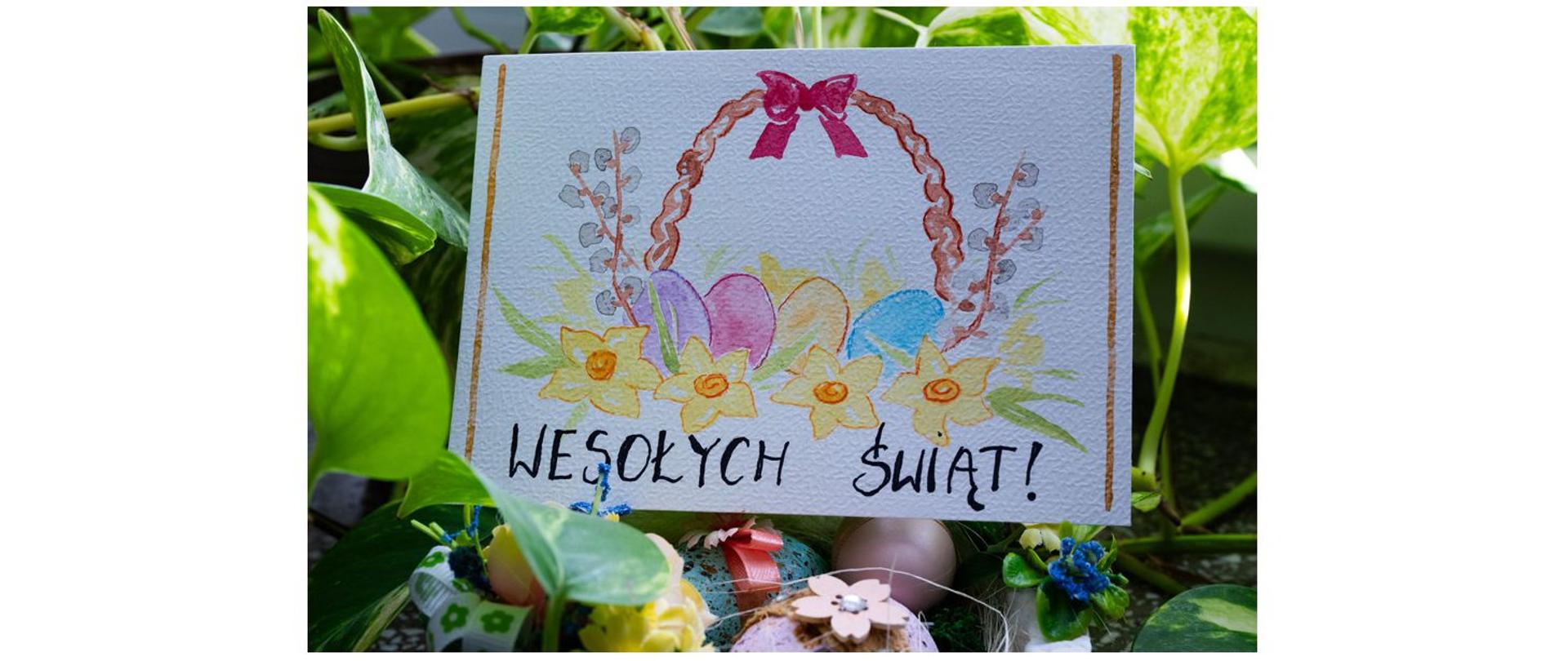 Zdjęcie przedstawia kartkę świąteczną na której jest namalowany koszyk z jajkami i kwiatami