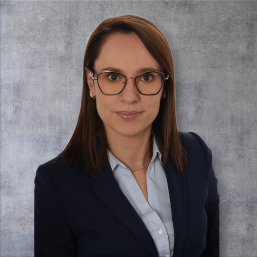 Zdjęcie przedstawia portret Pani Kierownik Wydziału Kontroli Justynę Magdziarz na marmurowym tle w okularach