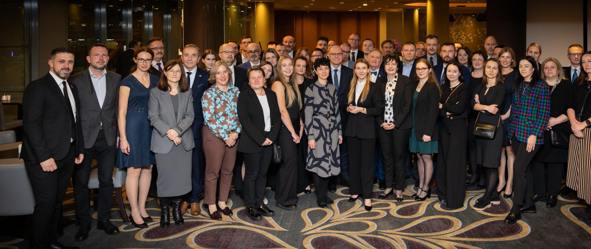 Duża grupa ludzi elegancko ubrana pozuje to zdjęcia 