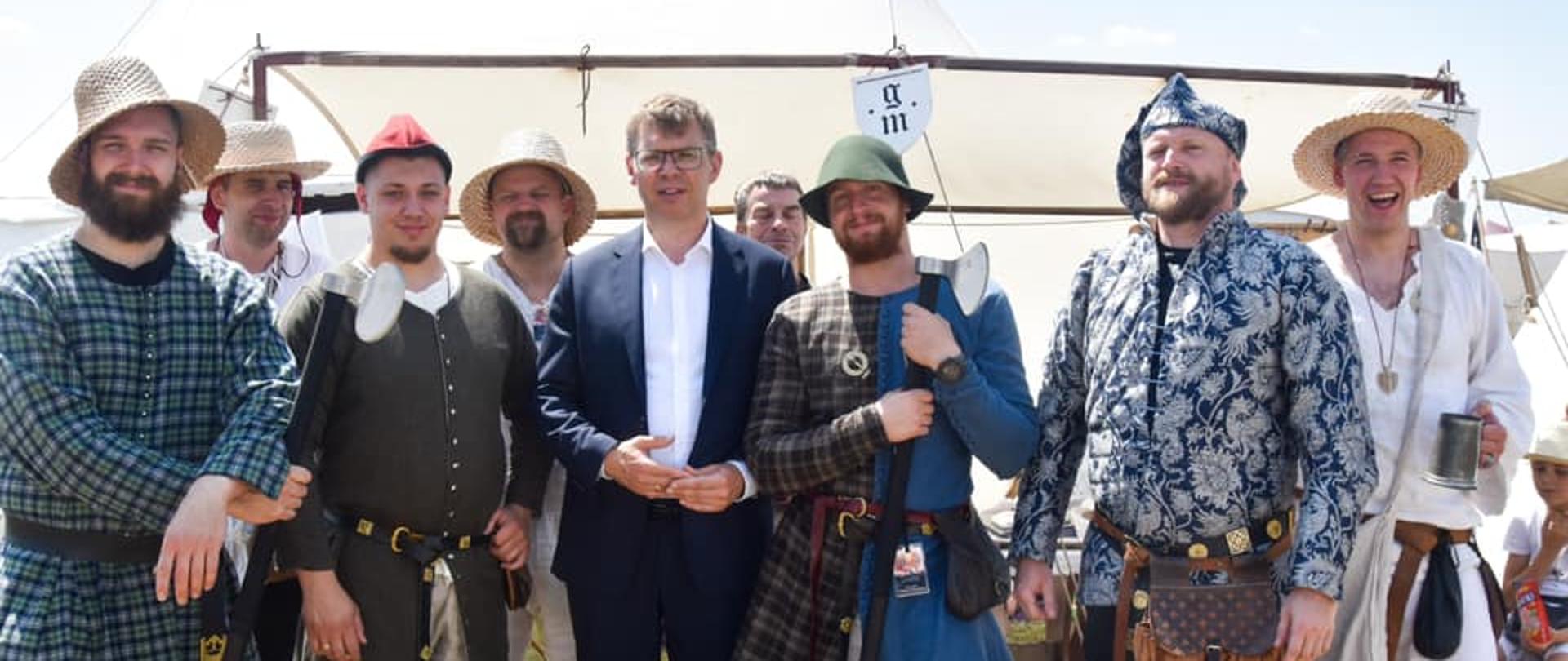 Wojewoda na Bitwie pod Grunwaldem stoi z osobami przebranymi za chłopów 