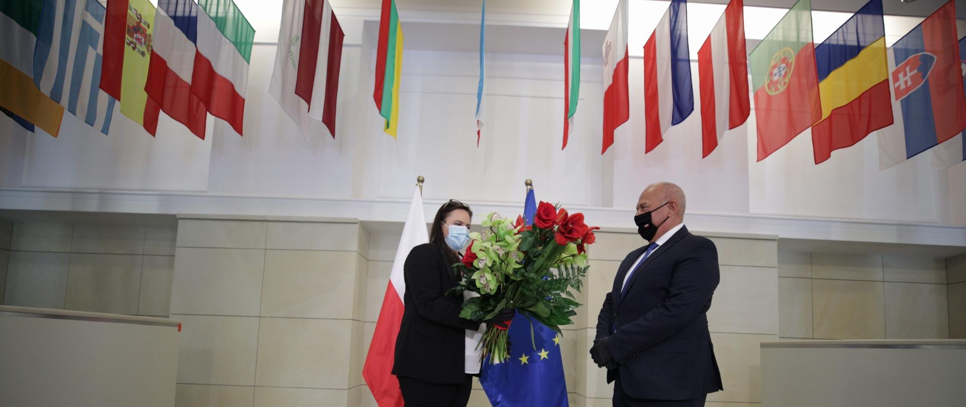 Małgorzata Jarosińska-Jedynak wręcza kwiaty na powitamie ministra Tadeusza Kościńskiego