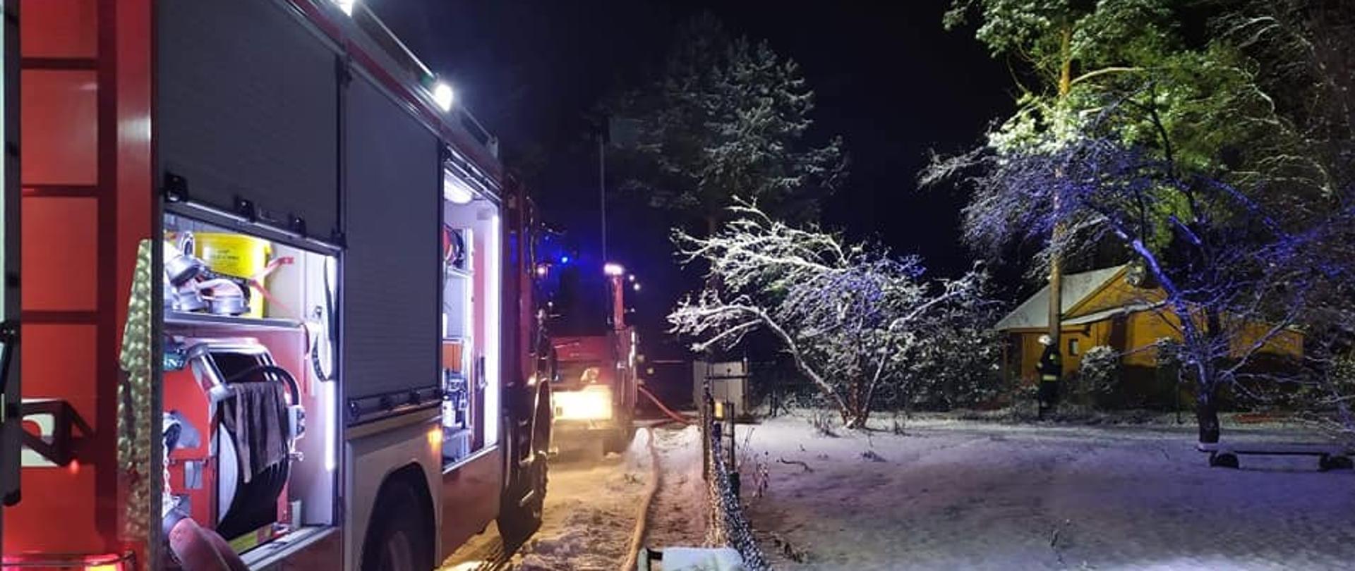 Samochody strażackie przy działaniach gaśniczych w zimowej aurze