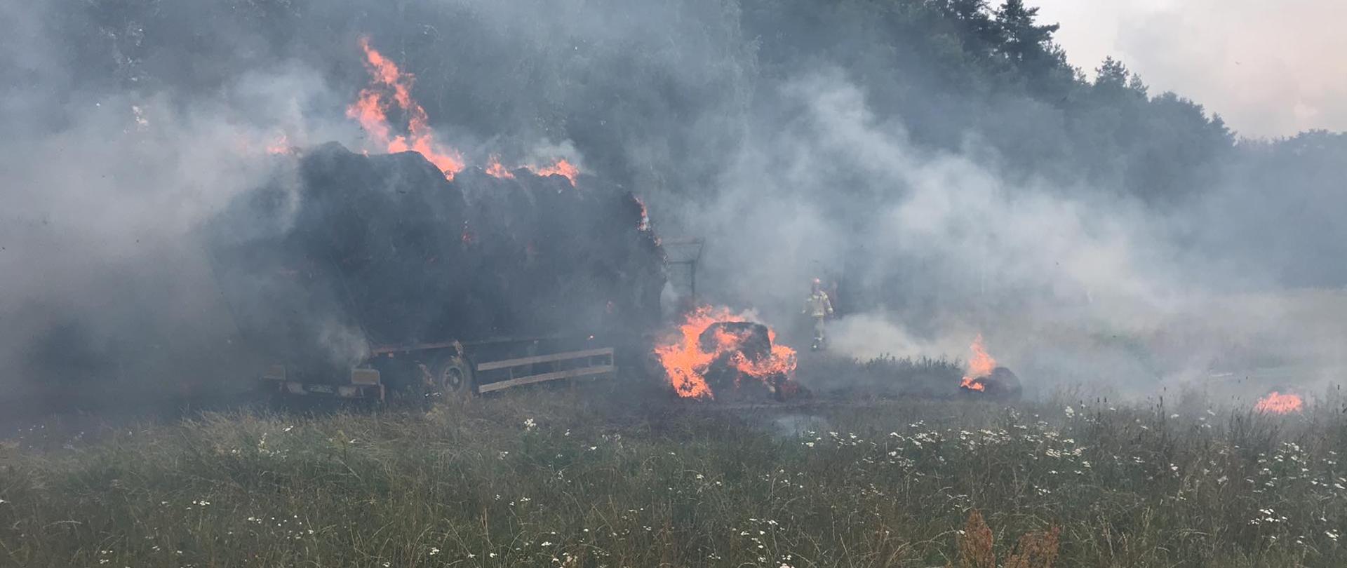 Na zdjęciu widać palące się baloty siana na przyczepie