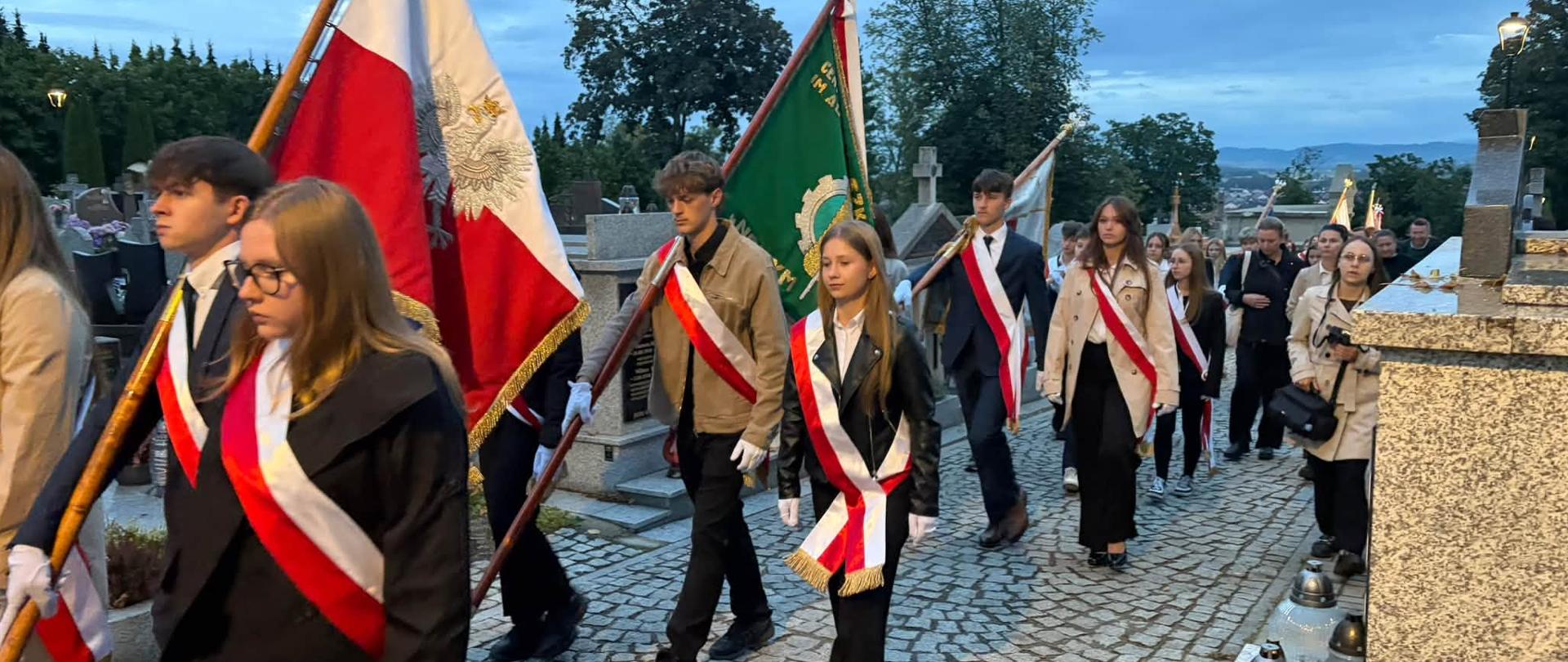 Zdjęcie uczniów ZSCKR idących w pochodzie ze sztandarem szkoły