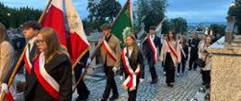 Zdjęcie uczniów ZSCKR idących w pochodzie na cmentarzu