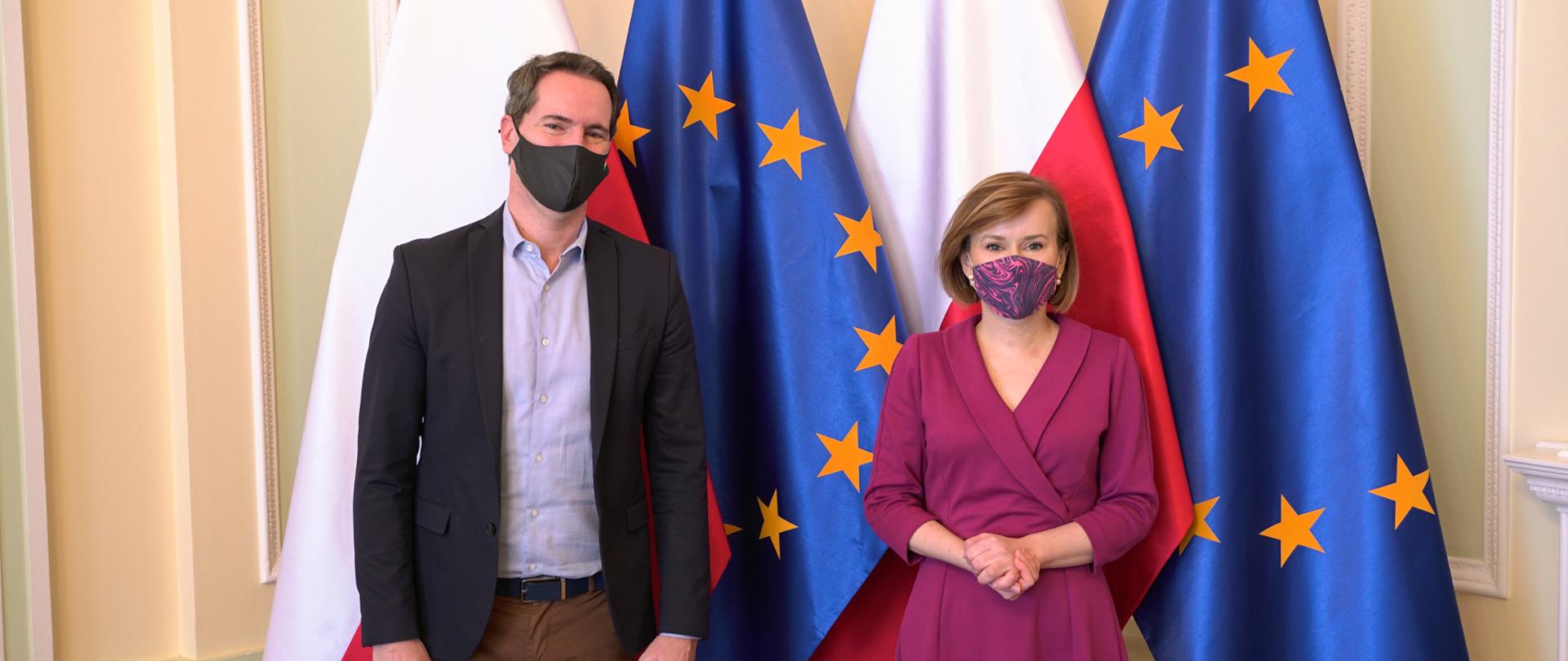 Minister Anna Krupka i Minister Péter Sárfalvi stoją przed flagami