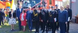 uczestnicy uroczystości strażacy druhowie politycy pozują do zdjęcia przed nowym samochodem pożarniczym