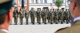 ododdział żołnierzy w pełnym umundurowaniu polowym stoi w szyku na Rynku w Bytomiu Odrzańskim podczas uroczystego apelu wojskowego.