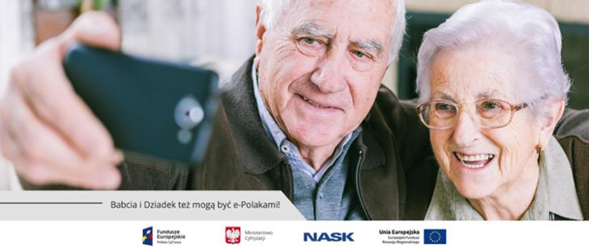 Grafika. Babcia i dziadek robią sobie zdjęcie telefonem komórkowym. Poniżej napis: Babcia i Dziadek tez mogą być e-Polakami!
