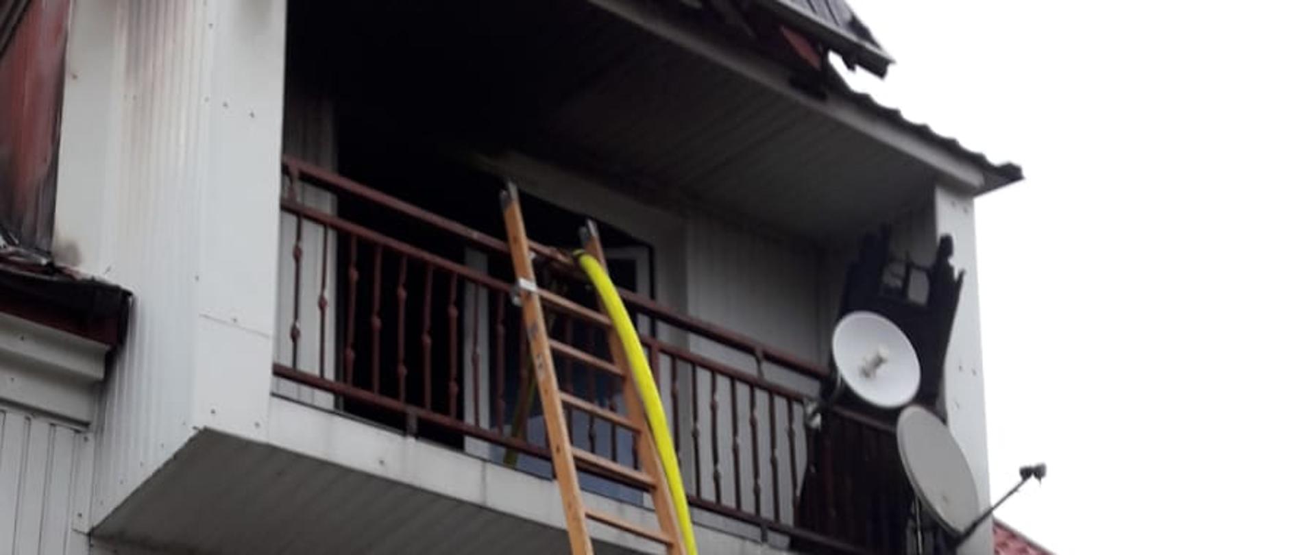Drabina i linia wężowa przystawiona do budynku