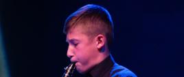 Zdjęcie przedstawia Adama Andrzejczaka, ucznia klasy klarnetu występującego podczas koncertu świątecznego.