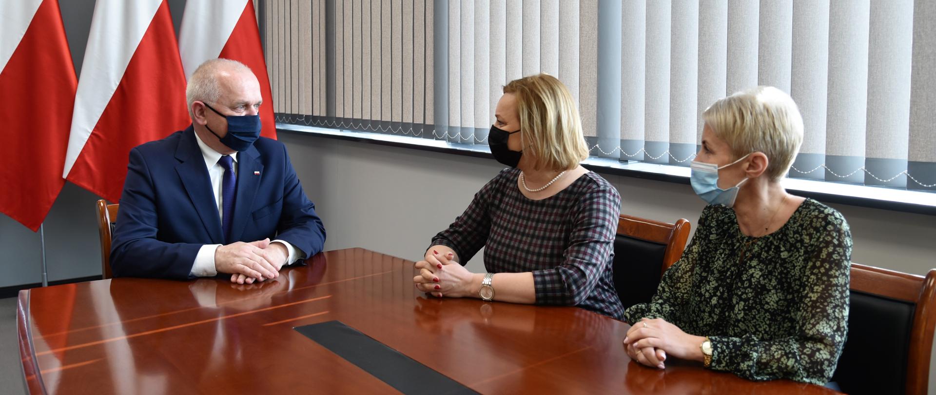 Wojewoda Władysław Dajczak rozmawia z burmistrz Dobiegniewa Sylwią Łaźniewską oraz prezes PUK Komunalni w Dobiegniewie Agnieszką Walendzik. W tle flagi