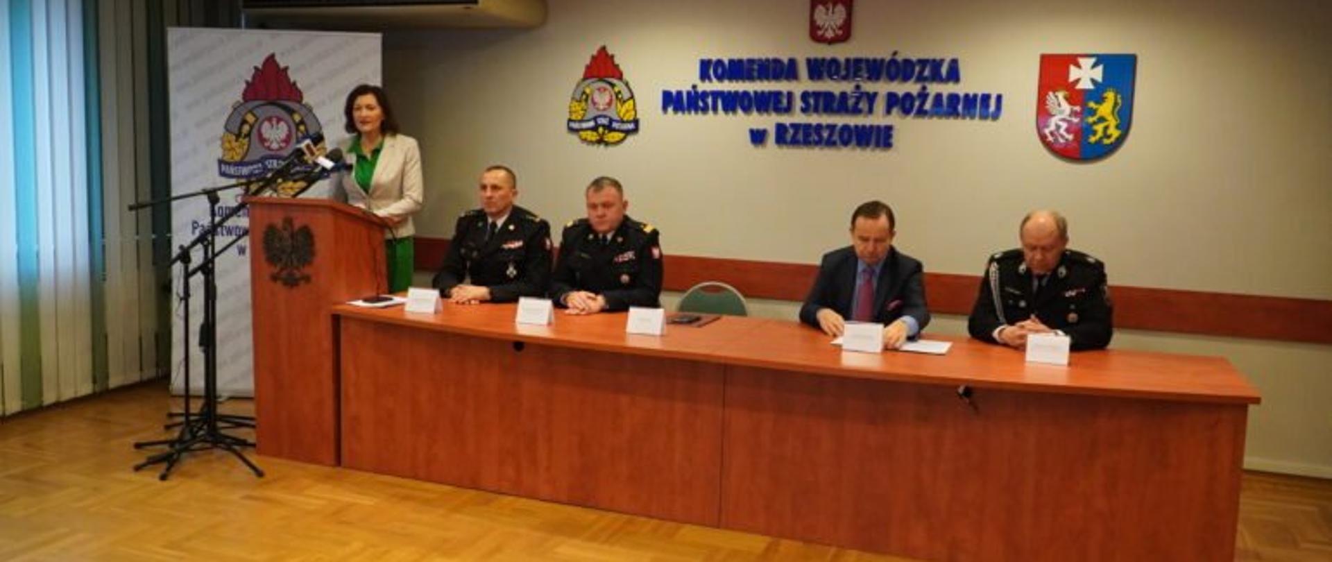 Od lewej wojewoda podkarpacki Ewa Leniart podczas przemówienia, obok siedzą zastępca komendanta wojewódzkiego PSP w Rzeszowie st. bryg. Daniel Dryniak, komendant wojewódzki nadbryg. Andrzej Babiec, marszałek województwa podkarpackiego Władysław Ortyl oraz Poseł na Sejm RP Zbigniew Chmielowiec