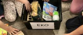 grafika przedstawia kosz z produktami ekologicznymi i dzieci wybierające takie produkty