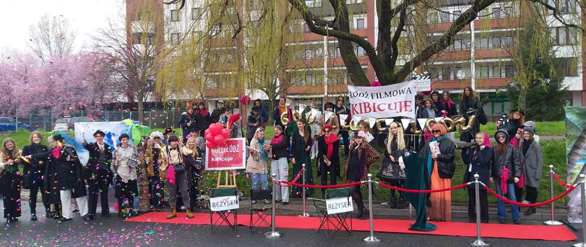 Na zdjęciu Punkt Kibica. Konfetti, transparenty, przebrana młodzież łódzkiego plastyka