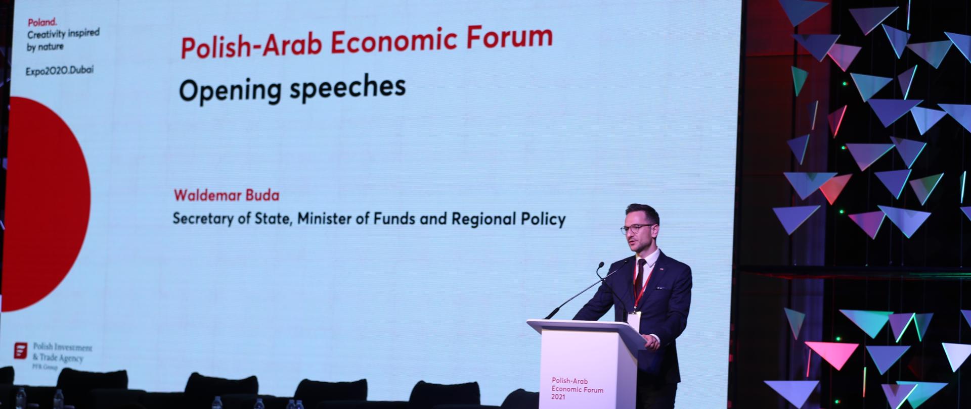 Minister Waldemar Buda przemawia na scenie. W tle Ekran wyświetlający nazwę wydarzenia. 