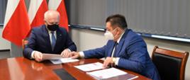 Wojewoda z Wójtem Słońska dyskutują w gabinecie przeglądając dokumenty.