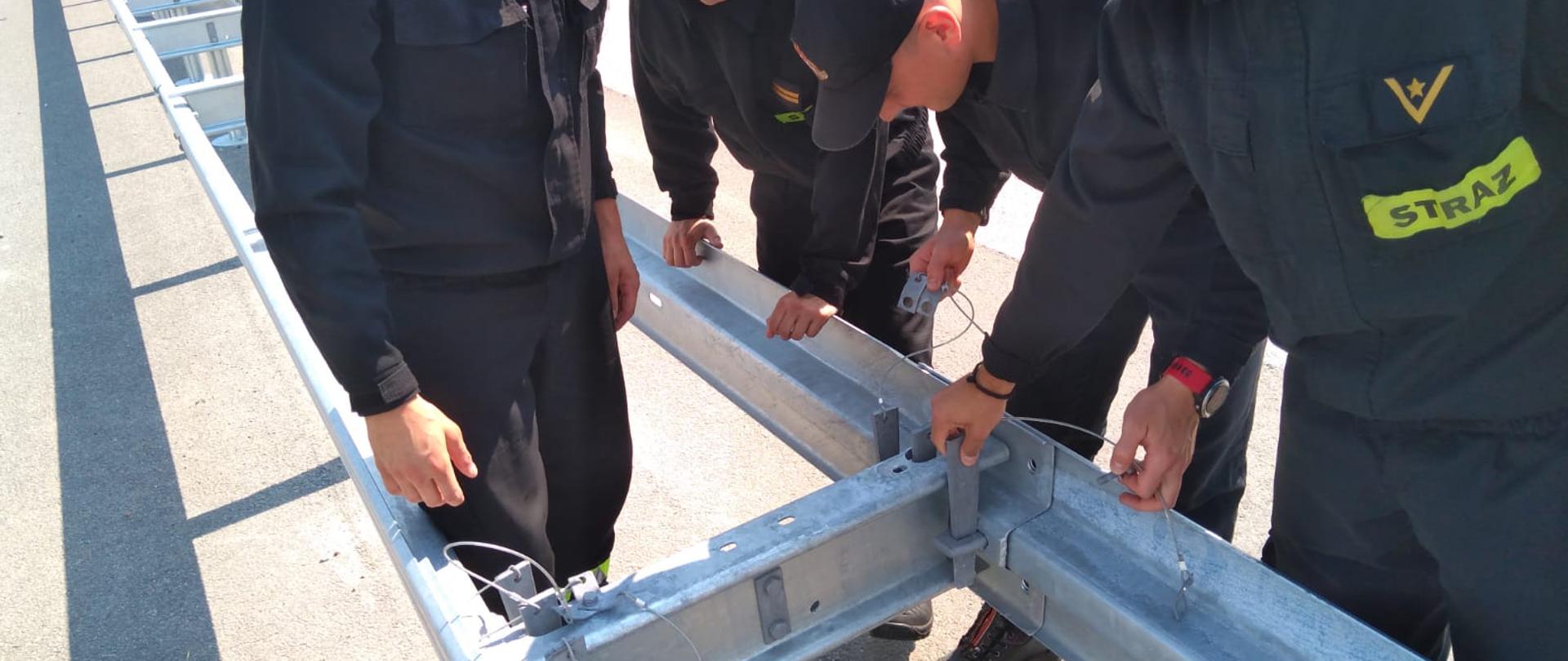 Próba demontażu barier ochronnych przez strażaków w ciągu drogi ekspresowej S-61