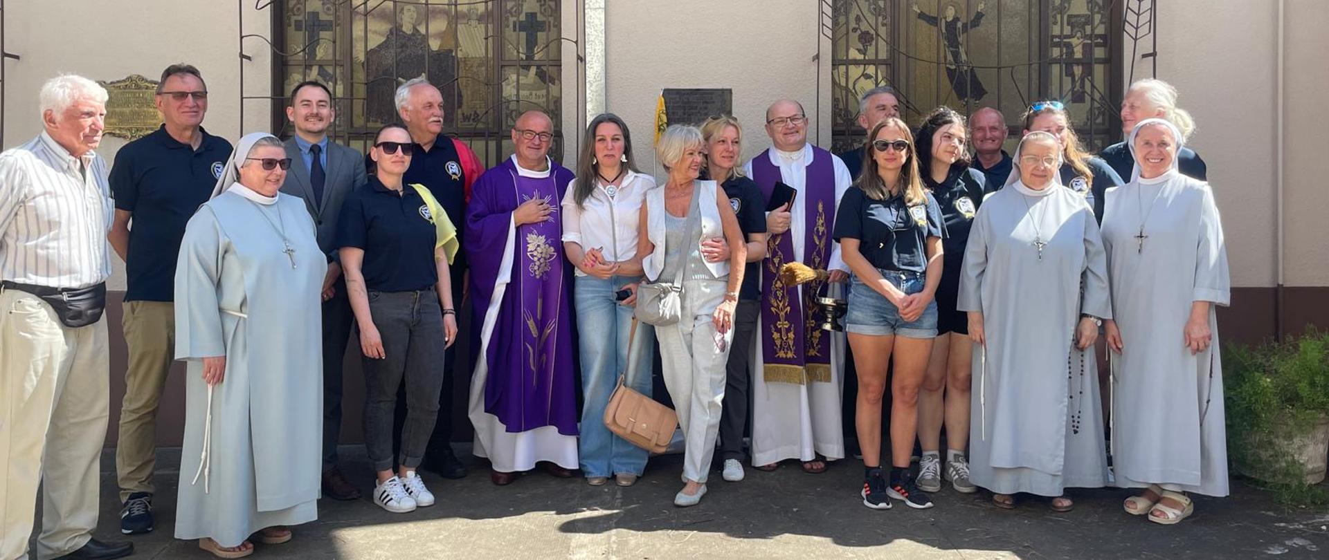 grupa osób na tle kościoła