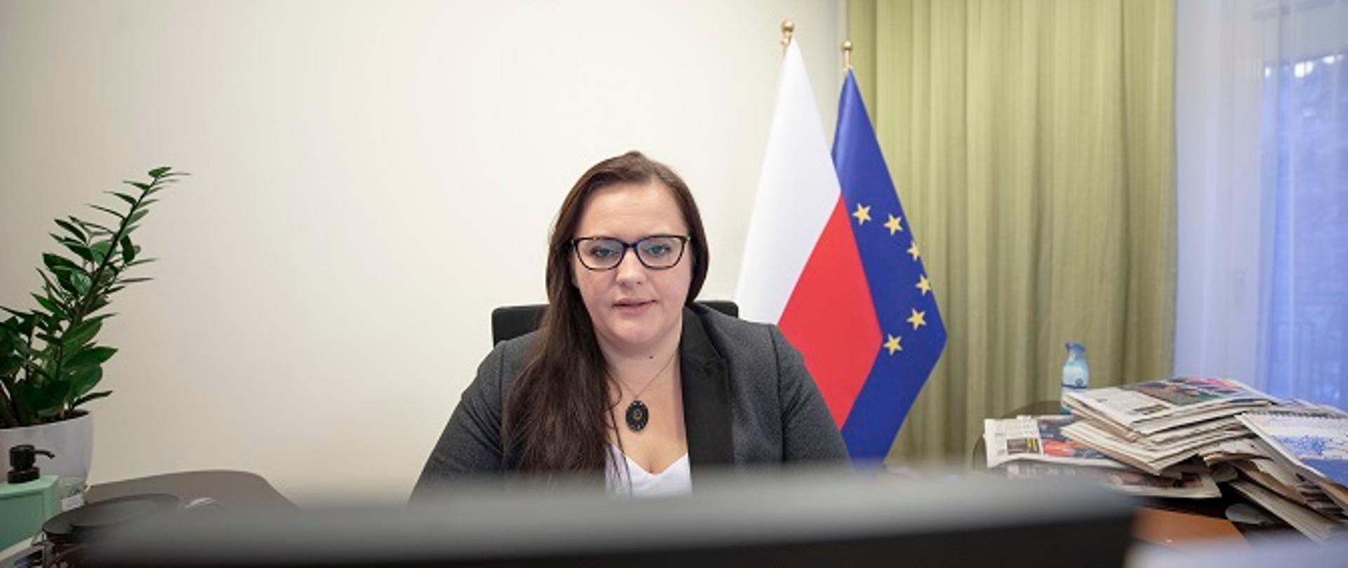 Deputy Minister is sitting behind the desk in her office.