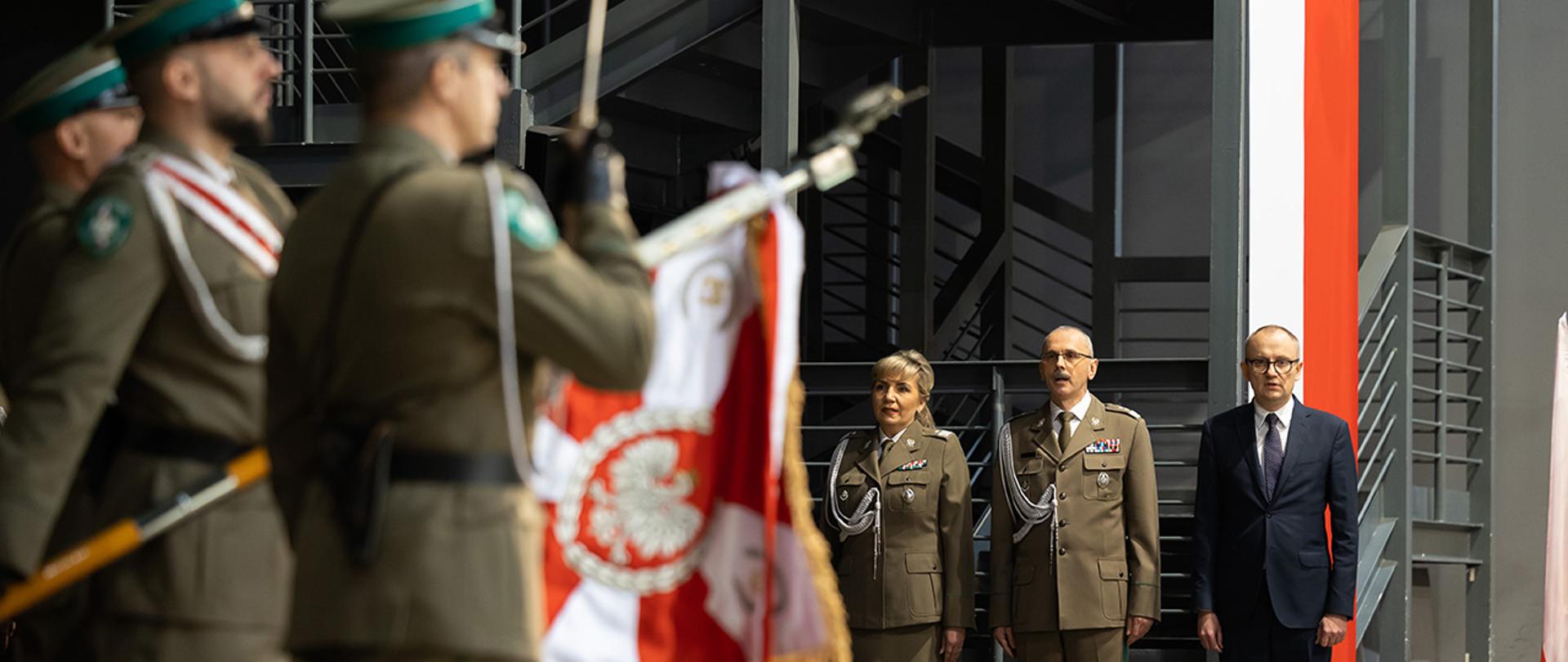 W tle stoi wiceminister Błażej Poboży, komendant główny SG i zastępca komendanta SG