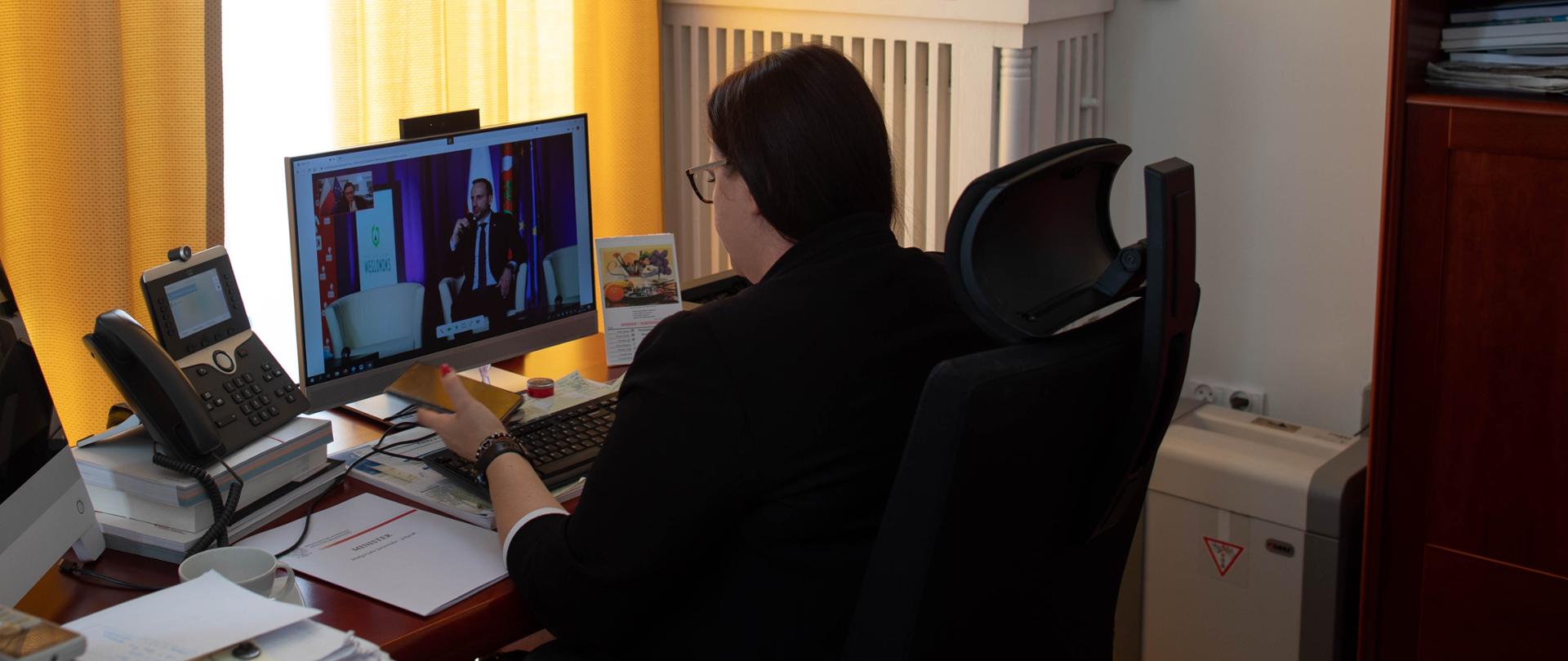 W pokoju biurowym przy monitorze stojącym na biurku siedzi minister Małgorzata Jarosińska-Jedynak 