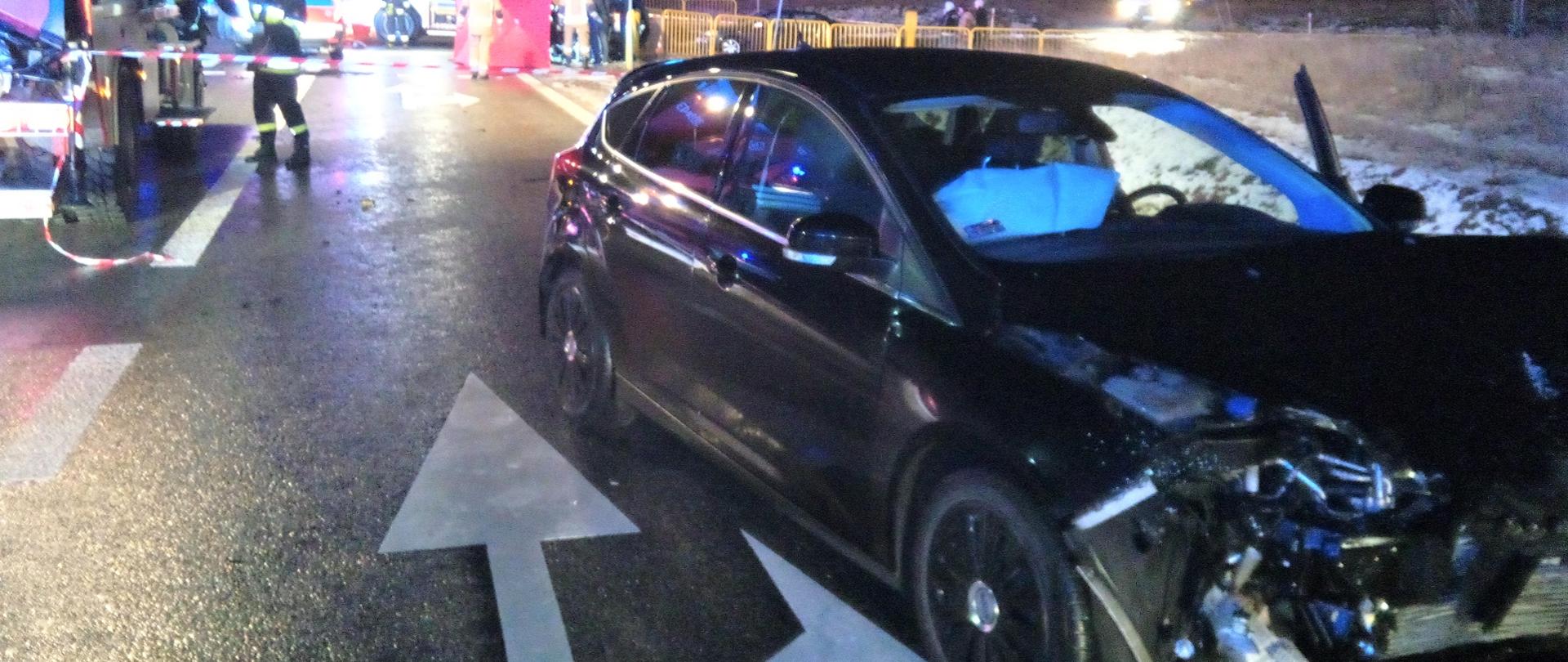 Na zdjęciu widzimy miejsce wypadku samochodowego w miejscowości Daleszyce. Na pierwszym planie samochód osobowy Ford Focus biorący udział w zdarzeniu. W tle samochody służb ratowniczych.