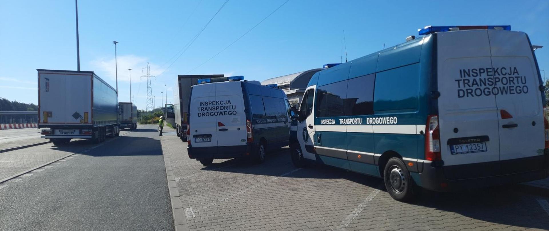Samochody inspekcji i zatrzymane pojazdy ciężarowe podczas kontroli.