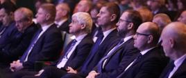Minister funduszy i polityki regionalnej Grzegorz Puda podczas konferencji inaugurującej Fundusze Europejskie dla Podlaskiego 2021-2027, minister siedzi na sali, po jego lewej stronie siedzi minister edukacji Dariusz Piątkowski, po lewej stronie marszałek województwa podlaskiego Artur Kosicki