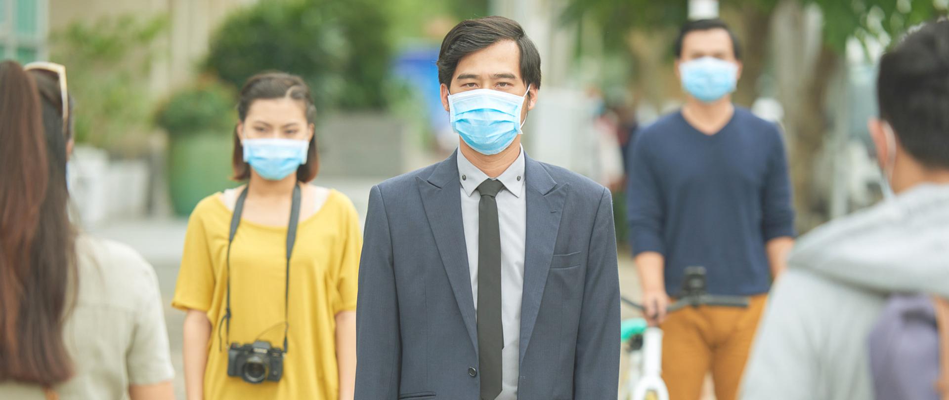 Asian people in face masks walking in ther street