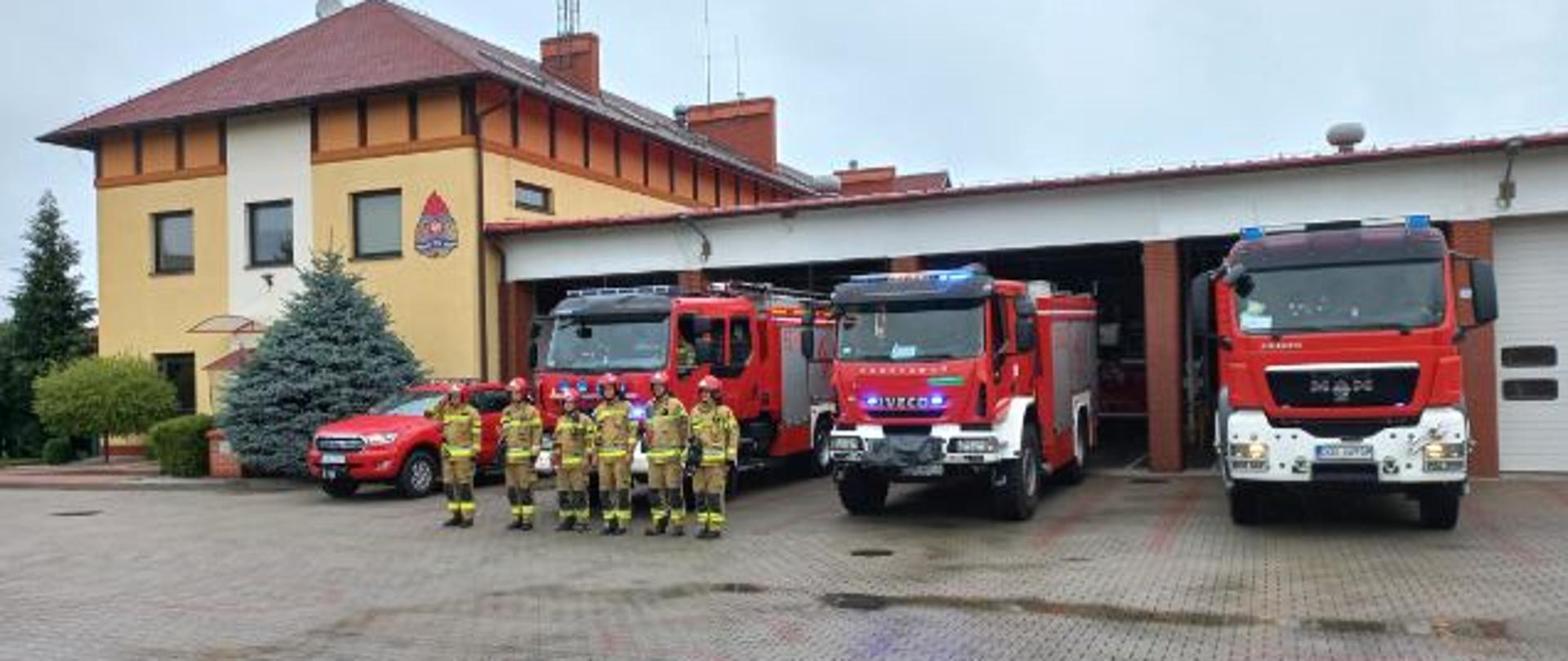 Na zdjęciu widać strażaków w umundurowaniu specjalnym, przed jednostką ratowniczo-gaśniczą PSP w Oławie, którzy przy włączonej sygnalizacji dźwiękowej w pojazdach uczcili rocznicę wybuchu Powstania Warszawskiego.