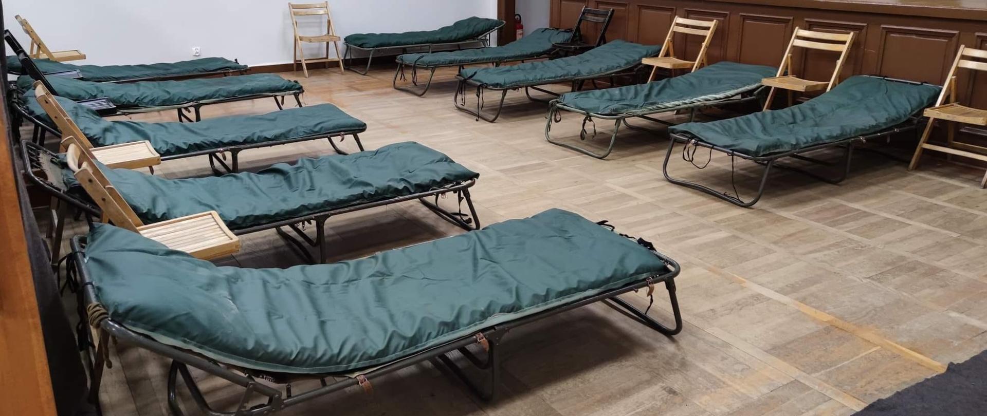 MIEJSCA NOCLEGOWE DLA UCHODŹCÓW Z UKRAINY. Na zdjęciu widać łóżka polowe przygotowane na sali strażnicy OSP. 