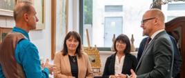 zdjęcia przedstawiają Ambasadora Republiki Łotewskiej oraz dyrekcję szkoły przed i w szkole oraz szkolnej galerii