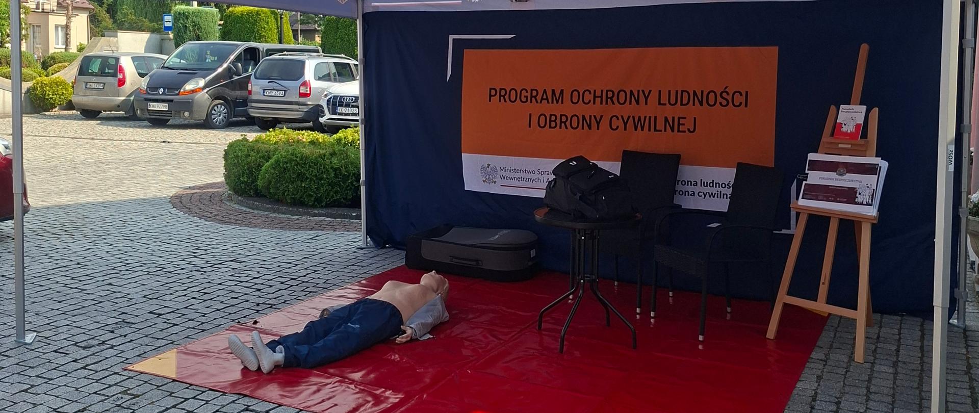 Na zdjęciu widać namiot Akademii OLiOC ze stanowiskami edukacyjnymi z zakresu poradnika bezpieczeństwa plecaka ewakuacyjnego i pierwszej pomocy. 