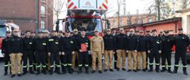 Pamiątkowe zdjęcie po ostatniej służbie st. ogn. Adama Lalewicza. Na zdjęciu obecni są funkcjonariusze zmiany II i III oraz funkcjonariusze systemu codziennego. 