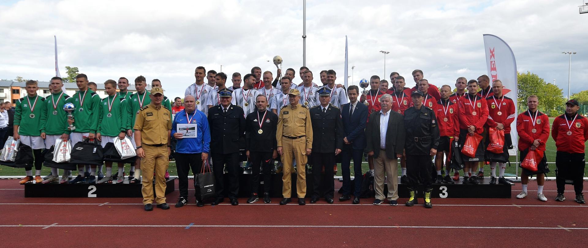 Zawodnicy i uczestnicy zawodów pozują do grupowego zdjęcia